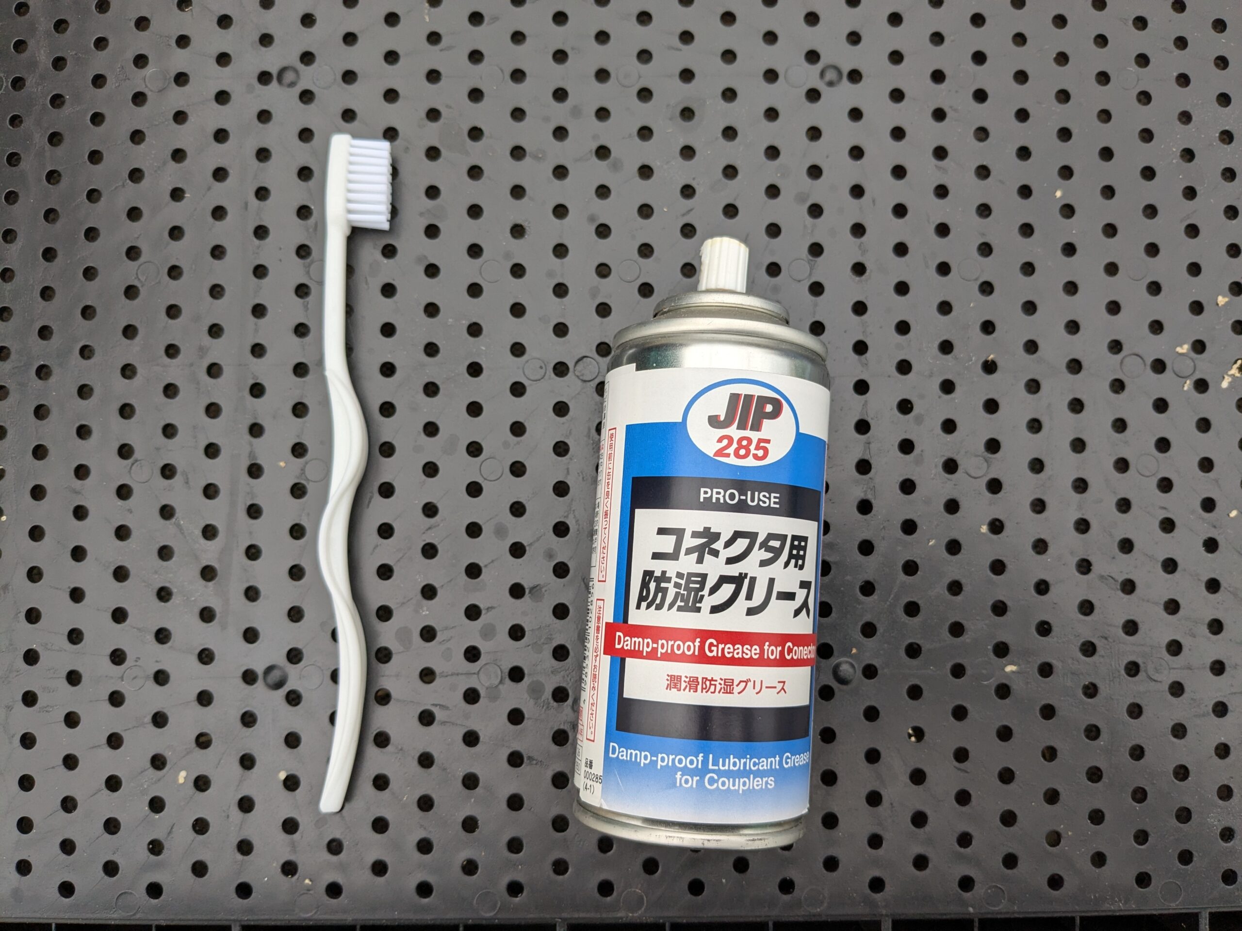 歯ブラシと、コネクタ用防湿グリース(JIP 285 コネクタ用防湿グリース)を並べた、用意するもの